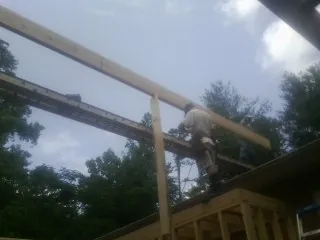 Carpenter setting a ridge beam over a new addition frame — Ice Dam Removal by Roofing Brothers in Crest Hill