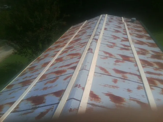 Rusted metal roof panels with new wood purlins before replacement — Storm Damage Roof Repair in Crest Hill by Roofing Brothers