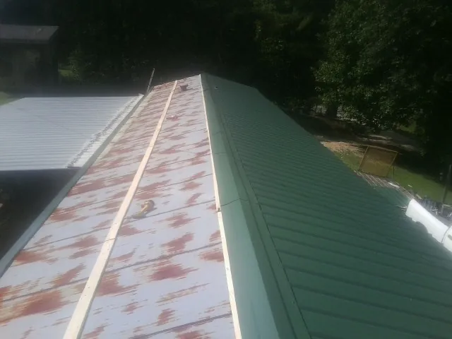 Old rusted panels beside newly installed green metal roofing — Wind Damage Roof Repair by Roofing Brothers in Crest Hill
