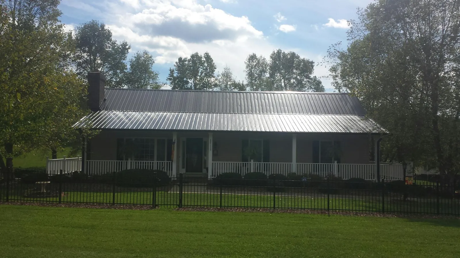 Gray metal roof on a brick ranch with a full width front porch — Gutter Guard Installation work by our crew in Crest Hill